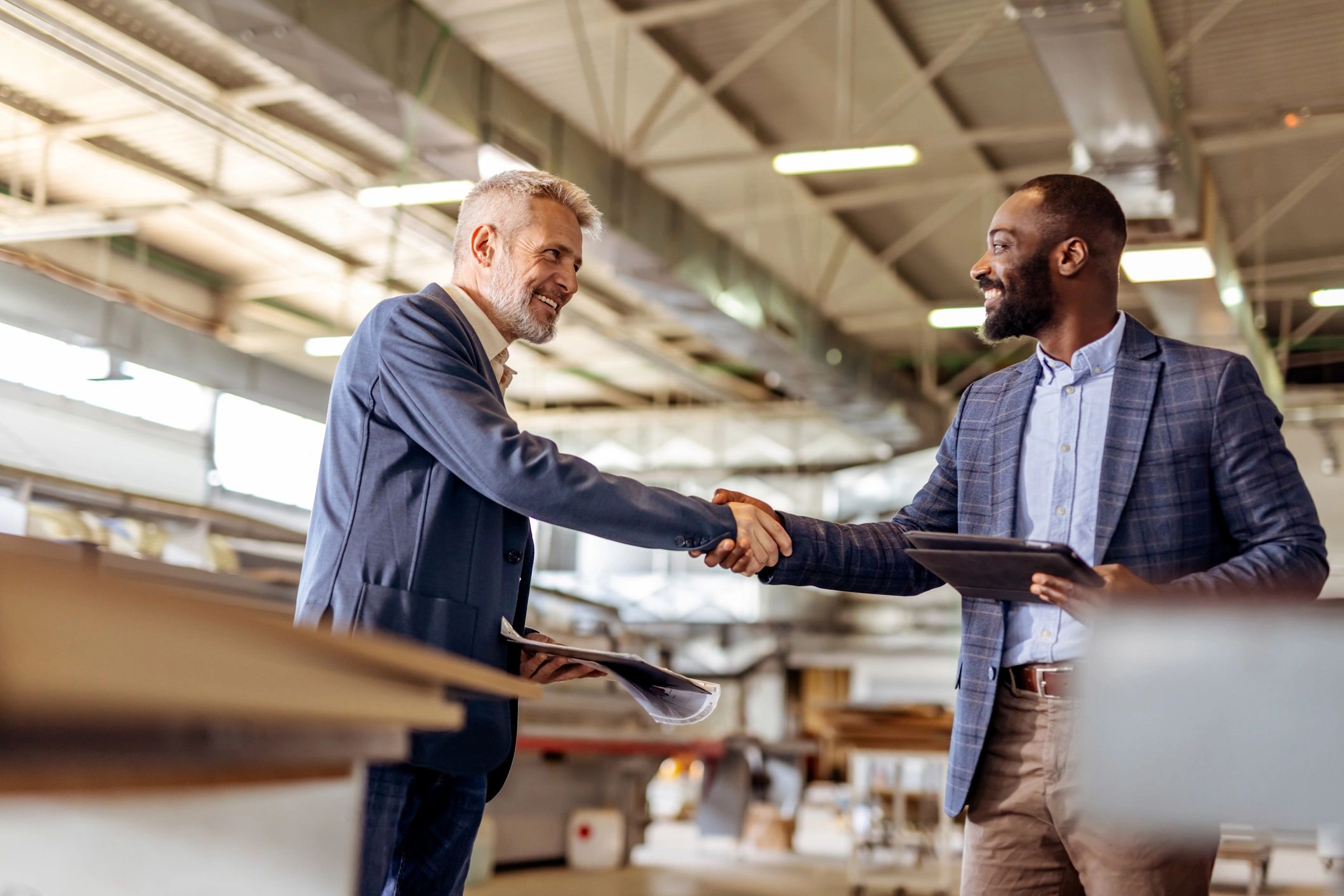 Professional Businessmen Shaking Hands During Commercial Agreement in a Modern Factory
