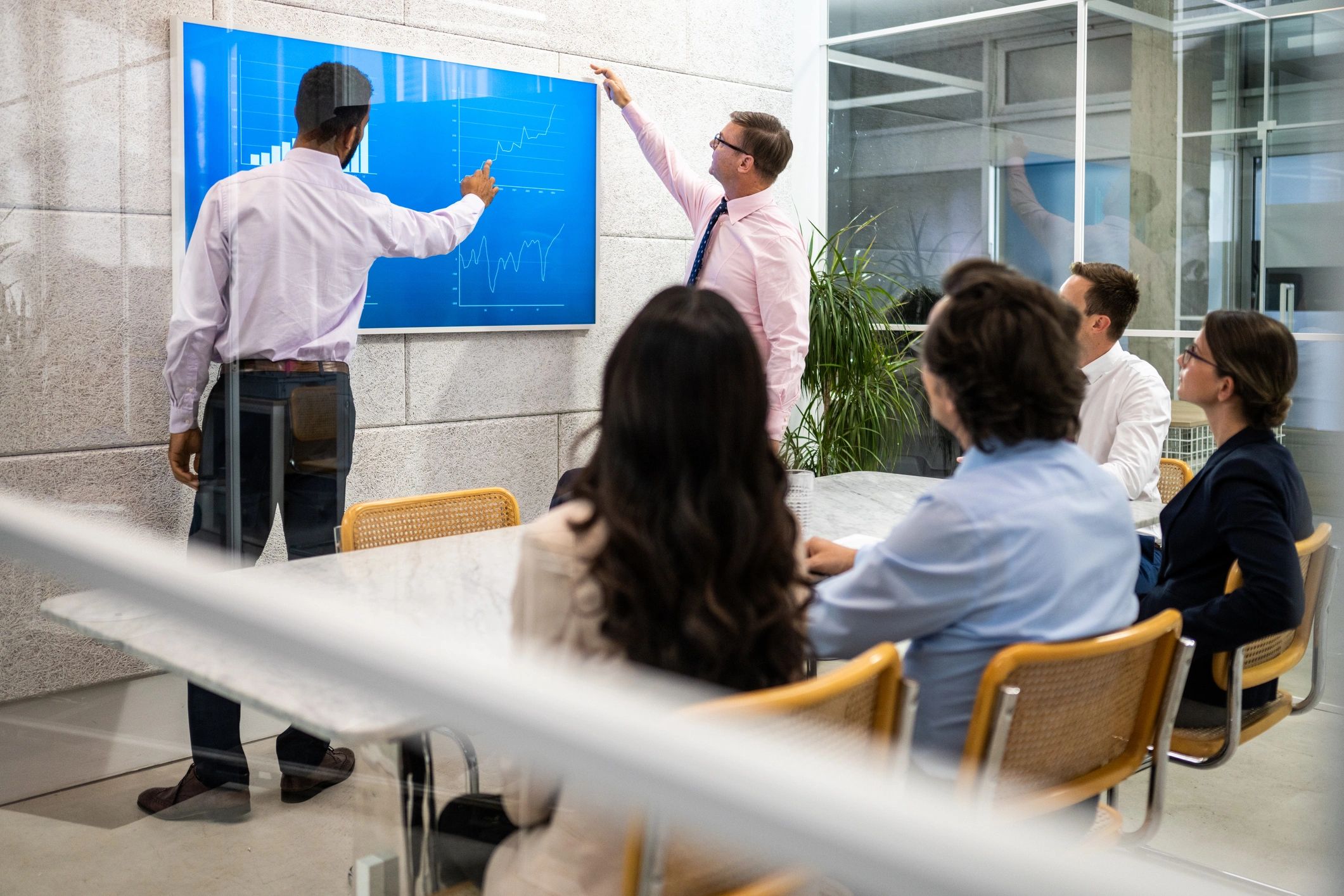 Corporate coworkers listening to financial statistics presentation in conference room